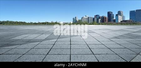 Leerer Marmorboden mit Stadtbild und Skyline in klarem blauen Himmel Stockfoto