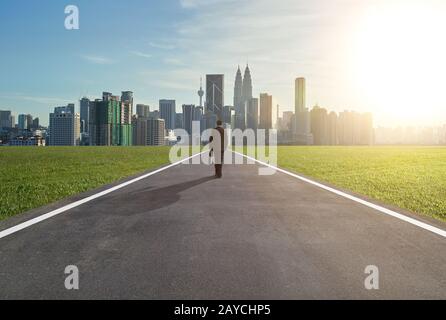 Bild eines männlichen Unternehmers, der auf der Straße unterwegs ist, während er Koffer trägt Stockfoto