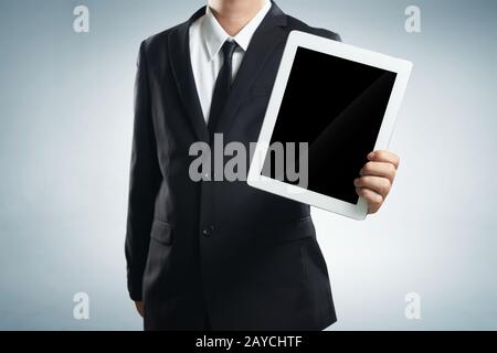 Erfolgreicher junger Geschäftsmann zeigt den Bildschirm des Tablets auf einem weißen Hintergrund Stockfoto