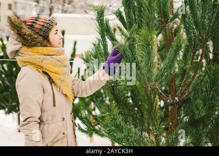 Thema ist das Symbol der Weihnachts- und Neujahrsfeiertage. Schöne junge kaukasische Kauffrau, wählt, kauft bei t Stockfoto