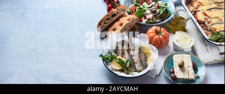 Griechische Küche. Moussaka, Meze, Souvlaki, Fisch, Pita, griechischen Salat, Tzatziki, Oliven und Gemüse. Traditionelle griechische Gerichte. Panorama Stockfoto