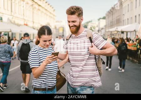 Paare Touristen beraten Stadt und Handy gps auf der Straße. Reisende. Paar, die den Standort auf dem Smartphone überprüfen. Techn Stockfoto