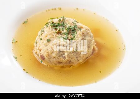Speckknödel in Suppe auf Holz Stockfoto