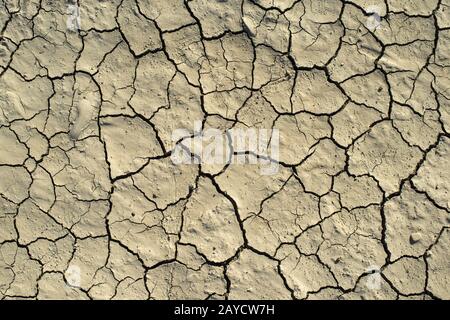 Gerissene Bodenbeschaffenheit. Harte Schatten und Sonne. Getrockneter Boden. Stockfoto