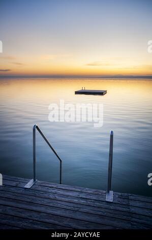 Sonnenuntergang bei Weiden am See mit Leiter und Schwimminsel Stockfoto