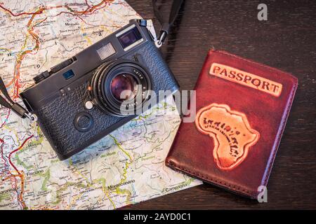 Reisefotografie-Konzept - Schwarz, Retro, Vintage-Fotokamera, Passport und Karte auf dunklem Holzhintergrund - Vintage-Look Stockfoto