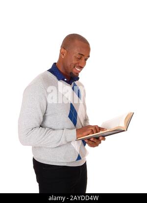 Afrikanischer Mann steht und liest ein Buch Stockfoto