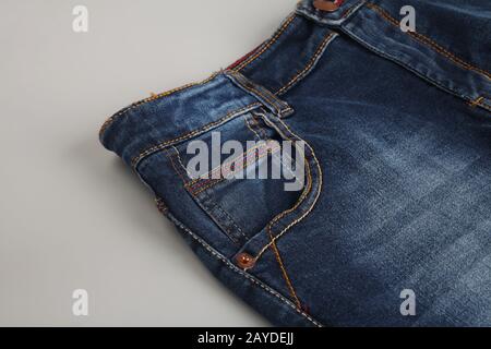 Titel: Blaue Jeans Hose isoliert auf grauem Hintergrund Stockfoto