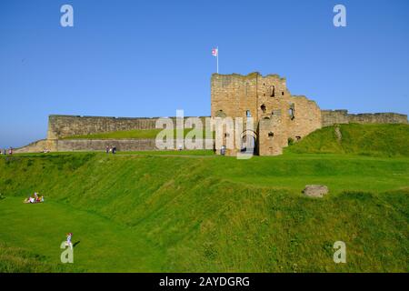 Die Menschen genießen sich im Tynemouth Priory and Castle an einem schönen sonnigen Sommernachmittag. Stockfoto