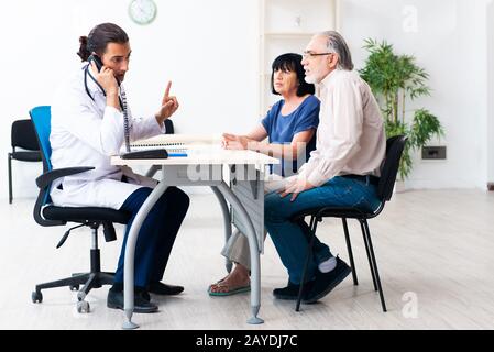 Altes Paar besucht jungen männlichen Arzt Stockfoto