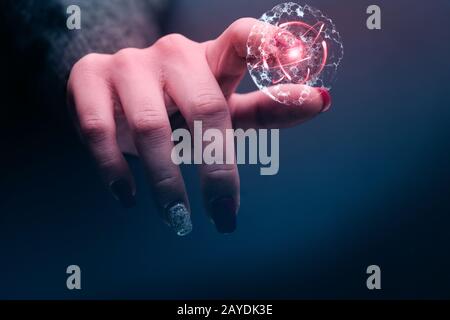 Der menschliche Zeigefinger berührt Zellteilung und Atom. Gemischte Medien. Stockfoto