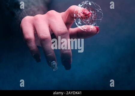 Der menschliche Zeigefinger berührt Zellteilung und Atom. Gemischte Medien. Stockfoto