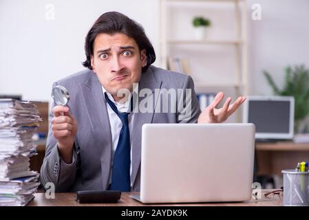 Junge männliche Mitarbeiter mit übermäßiger Arbeit unzufrieden Stockfoto