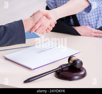 Verletzte Mitarbeiter besuchen Rechtsanwalt für Beratung zu Versicherungen Stockfoto