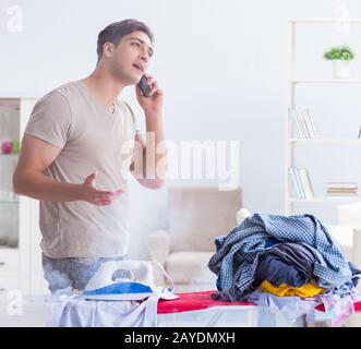 Die unaufmerksamen Ehemann brennende Kleidung beim Bügeln Stockfoto