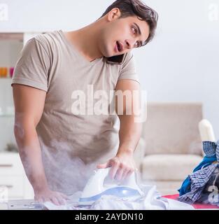 Unaufmerksam Mann brennende Kleidung beim Bügeln Stockfoto