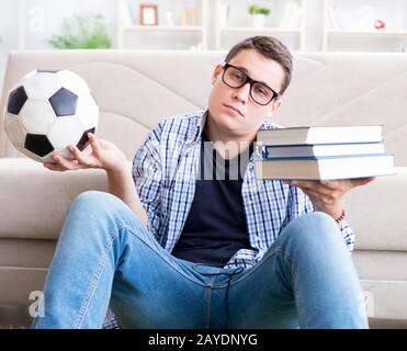 Junge Studenten, die versuchen, zu studieren und spielen Fußball Stockfoto