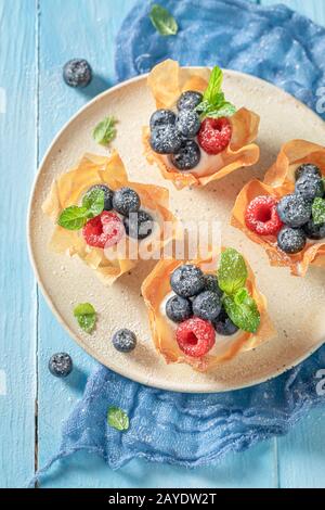 Frisch gebackene Phyllo-Becher aus Beerenfrüchten und Sahne Stockfoto