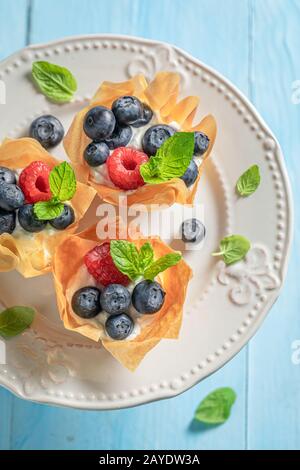 Frisch gebackene Phyllo-Tassen mit frischen Beeren und Schlagsahne Stockfoto