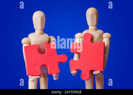 Holzspielzeug Figuren mit Puzzle auf Blau Stockfoto