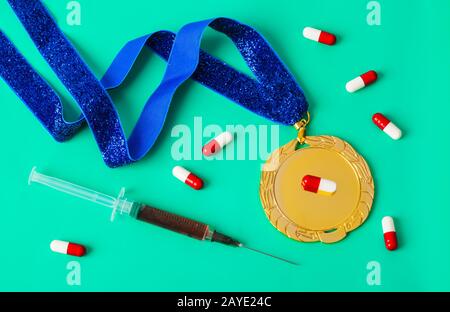 Goldmedaille mit Spritze und Pillen auf Grün Stockfoto