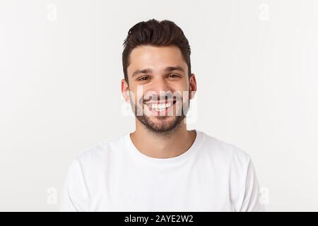 Porträt von einem gutaussehenden jungen Mann gegen gelben Hintergrund lächelnd Stockfoto
