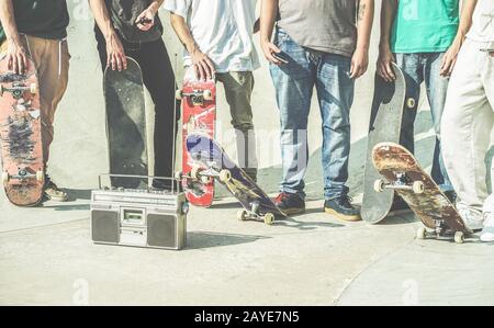 Junge Freunde, die Skateboards im Freien auf dem Skatepark der Stadt halten - Teenager Freunde, die Spaß beim Schlittschuhlaufen und Musikhören haben, draußen - Extremsport, F. Stockfoto