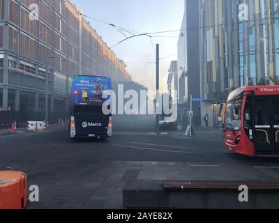 Stationäre Busse, die von einem Brand in einem Skip rauchen, schließen die Halsey Street im Wynyard-Viertel an Aucklands Hafengebiet ab. Stockfoto