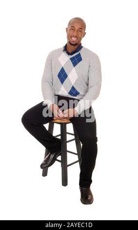 Afrikanischer Mann, der lächelnd auf einem Stuhl sitzt Stockfoto