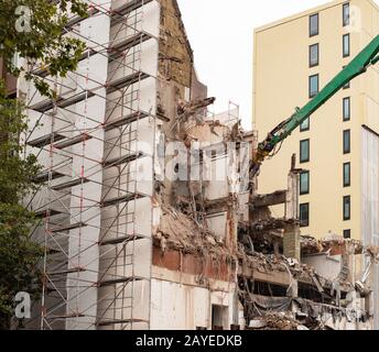 Abbruchbagger reißt ein Gebäude ab Stockfoto