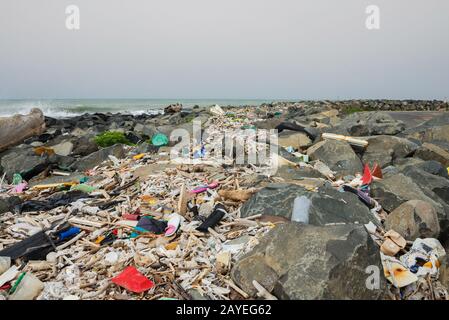 Verschüttete Müll am Strand in der Nähe der großen Stadt. Leere benutzten schmutzige Plastikflaschen und anderen Müll. Stockfoto