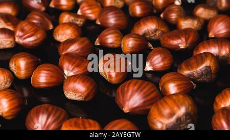 Reife Kastanien hautnah. Raw Kastanien für Weihnachten. Frische Kastanien. Essen Hintergrund Stockfoto