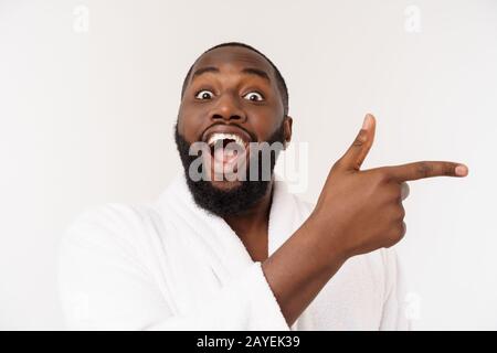 Schwarze Kerl trägt einen Bademantel Zeigefinger mit Überraschung und glückliches Gefühl. Über whtie Hintergrund isoliert. Stockfoto