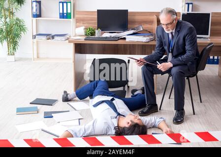 Forensische Ermittler und tote Mitarbeiter im Büro Stockfoto