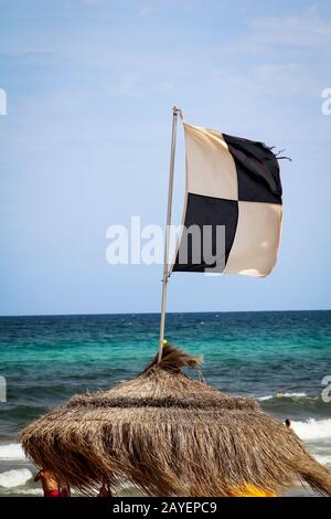 Flaggen am Strand weisen auf Gefahren wie Quallen, Unterstrom und andere Gefahren hin Stockfoto