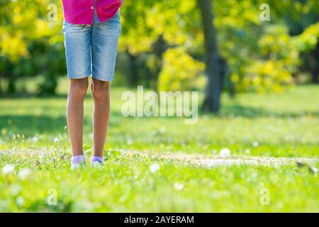 Kinder die Füße befinden sich auf der Wiese im Park. Close-up Stockfoto