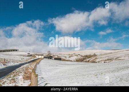 Weiß getünchte Hügelfarmen sind nicht so auffällig, wenn die Landschaft von Schnee bedeckt ist. Ettersgill, Upper Teesdale, Großbritannien Stockfoto