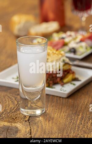 Griechische Ouzo mit Moussaka auf Holz Stockfoto