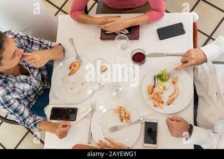 Stockfoto eines Tisches mit vier Personen, die bereits in einem Restaurant gegessen haben Stockfoto