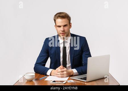Wir haben hier ein ernsthaftes Treffen. Fokussierter, erfolgreicher Geschäftsmann, Rechtsanwaltskanzlei lehnen sich auf den Schreibtisch und sehen sich die cli streng an Stockfoto