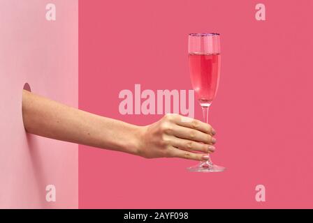 Die Hand der Frau hält ein Glas Roswein mit weichen Schatten. Stockfoto