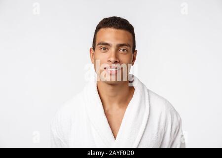 Afroamerikanischer Typ, der einen bademantel mit fröhlicher Emotion trägt. Isoliert über dem Hintergrund. Stockfoto