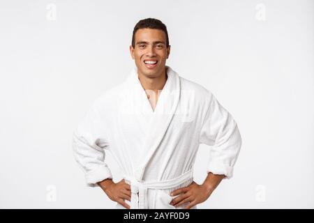 Afroamerikanischer Typ, der einen bademantel mit fröhlicher Emotion trägt. Isoliert über dem Hintergrund. Stockfoto
