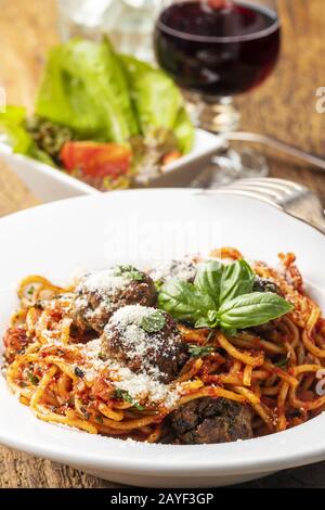 Spaghetti mit Fleischbällchen auf dunklem Holz Stockfoto