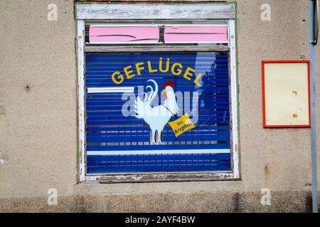 Ein Schaufenster eines ehemaligen Konsums der DDR mit Werbung für Geflügel Stockfoto