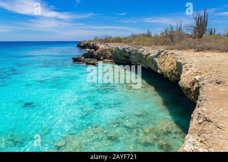 Felsige Küste mit flachem Wasser im blauen Meer Stockfoto