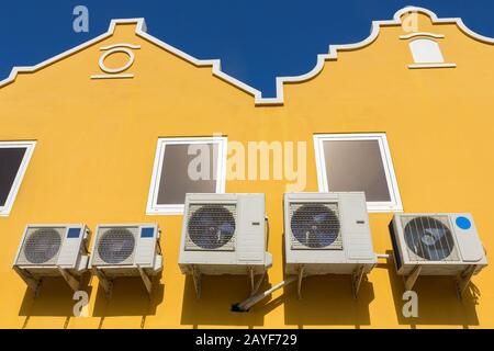 Klimaanlagen an der gelben Hauswand Stockfoto