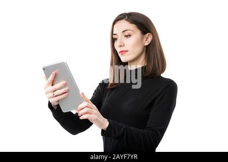 Frau Business Technology Thema. Schöne junge kaukasische Frau in schwarzem Hemd, das mit Tablettenhänden auf weißer Isola steht Stockfoto