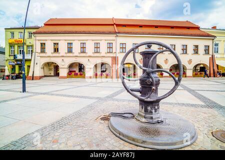 Vintage-Wasserpumpe auf dem Stadtplatz mit Museum für den Dialog der Kulturen Stockfoto