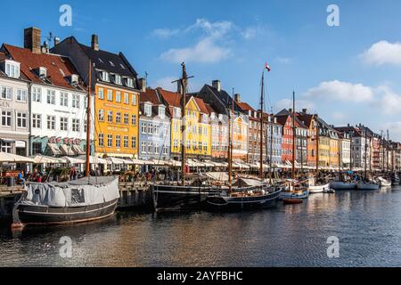 Nyhavn Canal mit bunten Gebäuden, alten pastellfarbenen Stadthäusern, Restaurants, Cafés und angedockten Booten im Zentrum von Kopenhagen, Dänemark Stockfoto